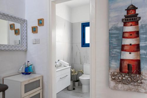 a bathroom with a red and white lighthouse painting on the wall at Protaras Villa Nicol 21 in Paralimni