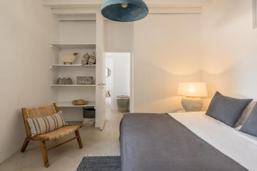 a bedroom with a bed and a chair and a lamp at Verina Terra in Platis Gialos