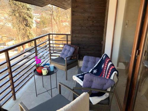 a porch with two chairs and a table on a balcony at Best Villa in BAKURIANI Center in Bakuriani