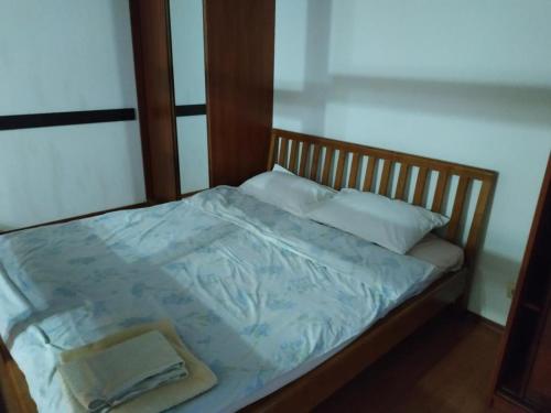Bett mit einem Kopfteil aus Holz und weißen Kissen in der Unterkunft Nice apartment near Gulliver in Kiew