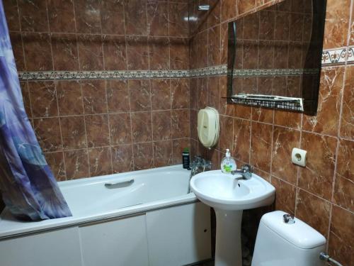 ein Badezimmer mit einem Waschbecken, einer Badewanne und einem WC in der Unterkunft Nice apartment near Gulliver in Kiew