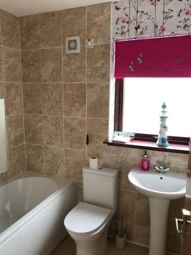 a bathroom with a white toilet and a sink at towerhill in Culloden