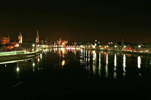 a city lit up at night with a body of water at towerhill in Culloden