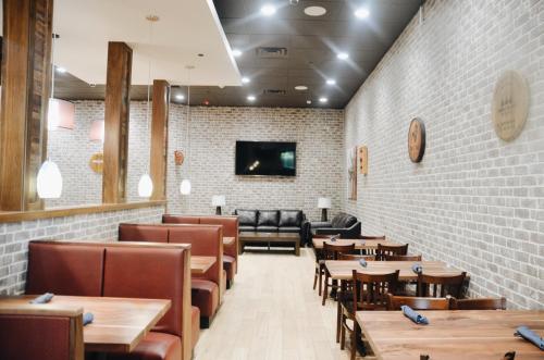 a restaurant with tables and chairs and a couch at Holiday Inn Lumberton by IHG in Lumberton