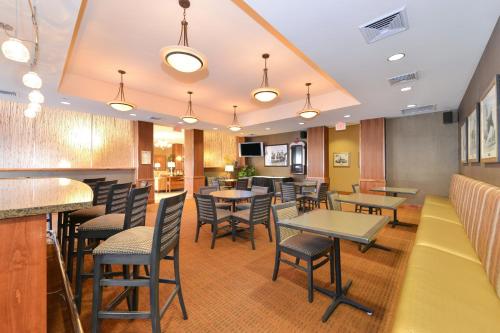 a restaurant with tables and chairs and a bar at Holiday Inn Laramie by IHG in Laramie