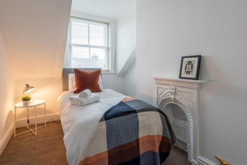 a bedroom with a bed with a fireplace at Perfectly Located 4 Storey Townhouse With 2 Parking Spaces In Central Harrogate in Harrogate