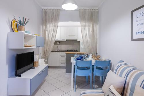 馬爾恰納的住宿－Casa Gelso，厨房以及带桌子和蓝色椅子的客厅。