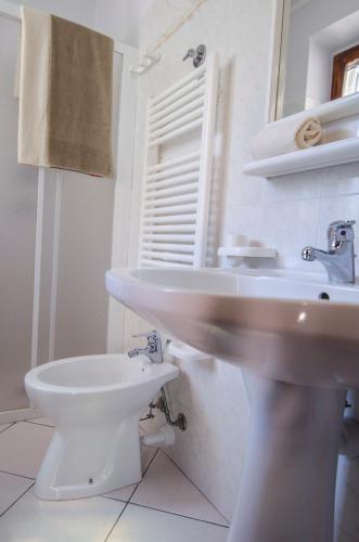 a white bathroom with a sink and a toilet at Casa Gelso in Marciana