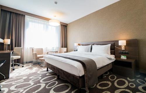 a hotel room with a bed and a desk at Holiday Inn Dąbrowa Górnicza-Katowice by IHG in Dąbrowa Górnicza