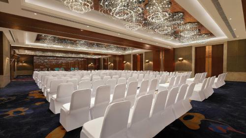 a row of white chairs in a room with chandeliers at Holiday Inn Jaipur City Centre by IHG in Jaipur