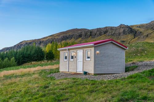 a small shed on a hill in a field at Ravencliff Lodge in Búðardalur