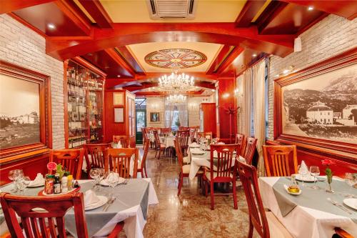 a restaurant with tables and chairs and a chandelier at Hotel Montenegrino in Tivat