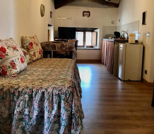 um quarto com uma cama e uma cozinha com um frigorífico em La Sorpresa Di Civita em Bagnoregio