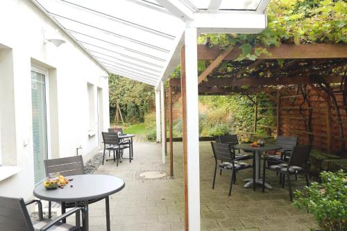 a patio with tables and chairs under a pergola at Pension Anja Heil in Meißen