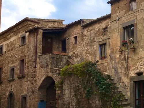 an old stone building with a window and a door at La Sorpresa Di Civita in Bagnoregio