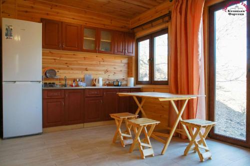 a kitchen with a refrigerator and a table and chairs at Козацька Фортеця in Pliskachevka