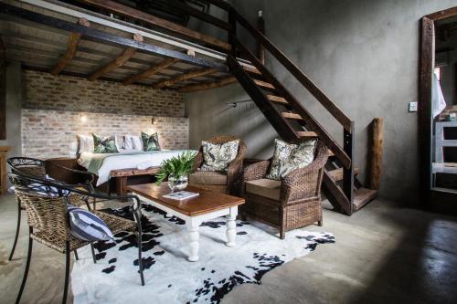 1 dormitorio con 1 cama, mesa y sillas en Breathe River Retreat en Parys
