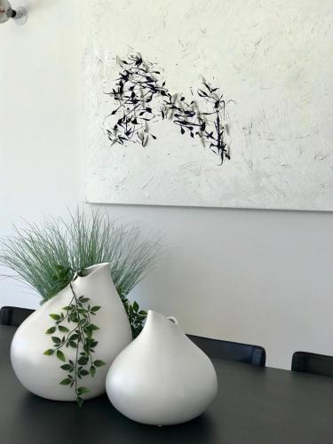 two white vases sitting on top of a table at La Maison d AME - for the perfect stay at the Mont Ventoux in Malaucène
