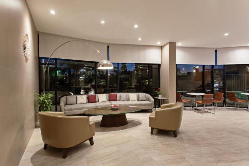 a living room with a couch and a table and chairs at Holiday Inn Long Beach - Airport by IHG in Long Beach