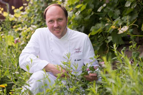 a chef sitting in a garden holding a plant at Gutshof Andres in Kirchlauter