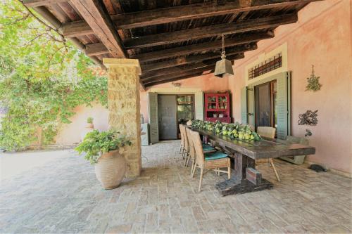 a porch with a wooden table with fruit on it at The Seacret Beachfront Villa in Néa Péramos