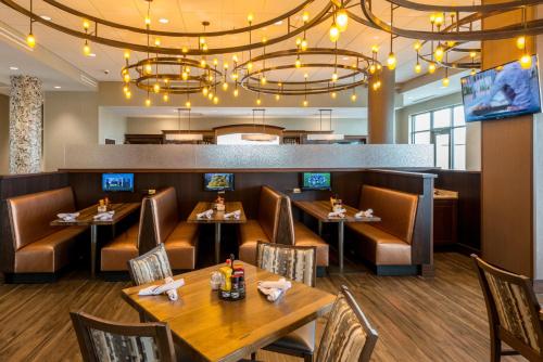 a restaurant with tables and chairs and a bar at Holiday Inn Lexington - Hamburg by IHG in Lexington