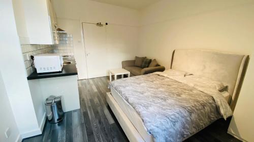 1 dormitorio pequeño con 1 cama y 1 sofá en Small Self Contained Studio In Sutton Coldfield en Birmingham