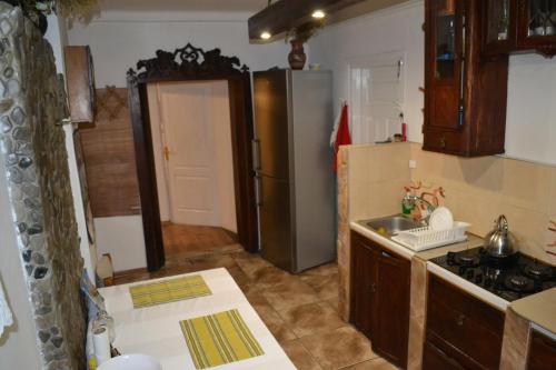 eine Küche mit einem Kühlschrank aus Edelstahl und einer Spüle in der Unterkunft Гостьовий дім у Почаєві in Potschajiw