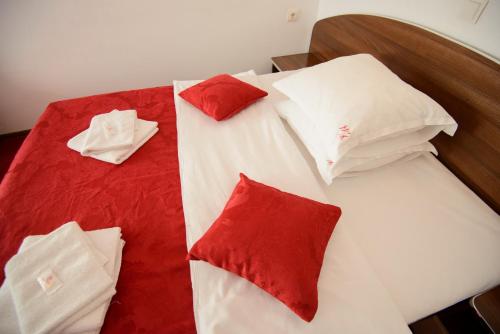 a bed with red and white pillows on it at Vila Moecel in Moieciu de Sus