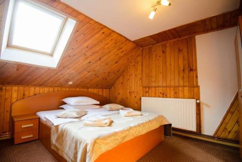 a bedroom with a bed in a wooden room at Vila Moecel in Moieciu de Sus