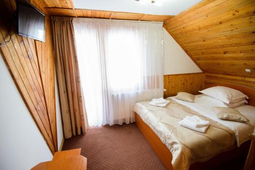 a bedroom with a bed in a room with a window at Vila Moecel in Moieciu de Sus