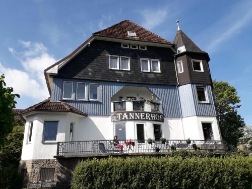 ein blau-weißes Haus mit zwei Leuten davor in der Unterkunft Villa Tannerhof in Braunlage