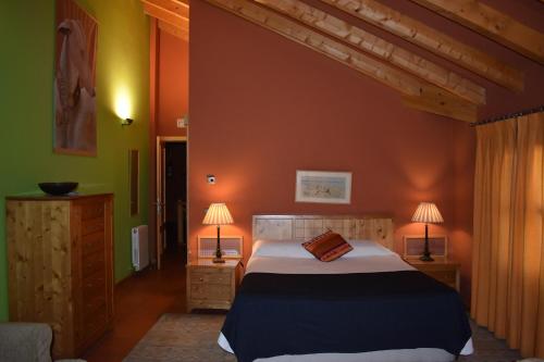 a bedroom with a large bed and two lamps at Hotel Sara De Ur in La Cabrera