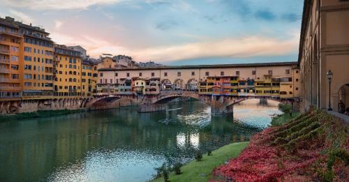 a bridge over a river in a city with buildings at Dimora Pieri in Florence