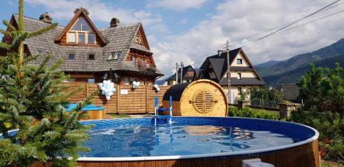 a house with a swimming pool in front of a house at Rezydencja Delta Boutique in Kościelisko