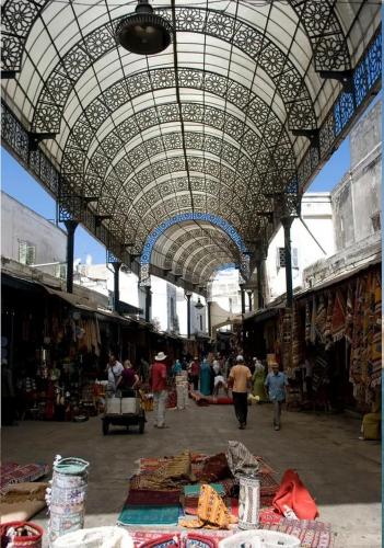 a market with awning over a market with people walking around at Riad Des Plages in Bouznika