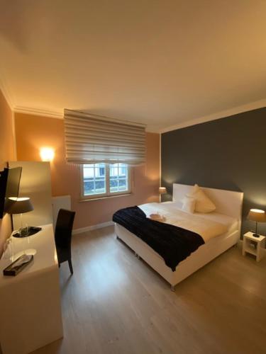 a bedroom with a bed and a desk with a computer at Hotel Sophia in Warendorf