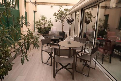 a patio with tables and chairs in a restaurant at Hôtel Brésil Opéra SPA in Paris