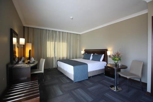 a hotel room with a bed and a table and chairs at Kaya Prestige in İzmir