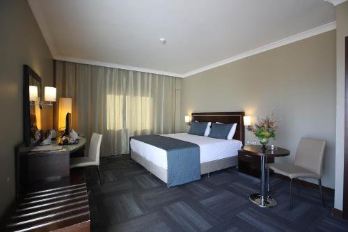 een hotelkamer met een bed, een tafel en stoelen bij Kaya Prestige Oteli in Izmir