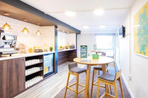 a kitchen with a table and two stools at Holiday Inn Leicester City by IHG in Leicester