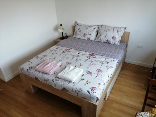 uma cama com lençóis e almofadas cor-de-rosa e brancas em Super Central & Panoramic Nick's Apartment em Pristina