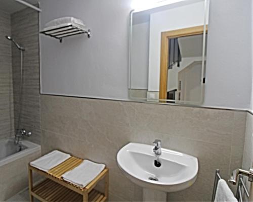 łazienka z umywalką i lustrem w obiekcie Casa Puerta de la Alcazaba Antequera w mieście Antequera