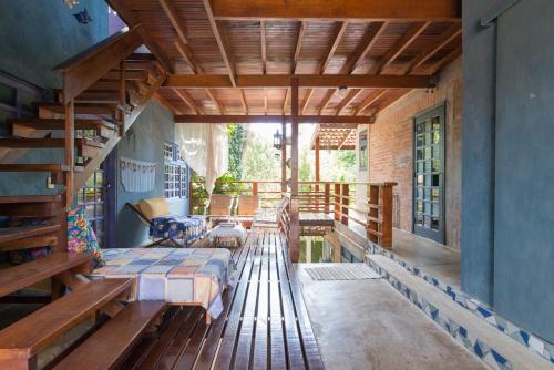 a porch of a house with a bed and a staircase at Mandala Maresias in Maresias