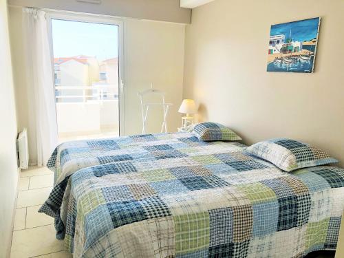 une chambre avec un lit avec une couverture à carreaux dans l'établissement PALMA T3 confort parking centre, à Arcachon