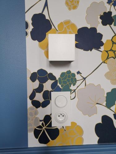 a picture of a phone on a wall with flowers at Manoir des Carreaux Chambres d'hôtes in Ingouville