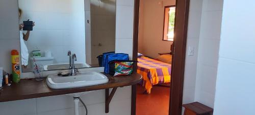 uma casa de banho com um lavatório, um espelho e uma cama em Pousada Casa da Edinha na Ilha de Boipeba