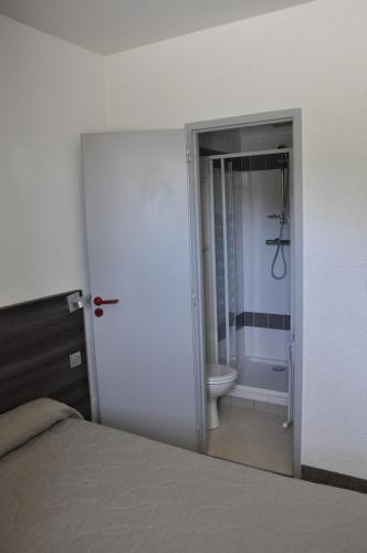 a bedroom with a bathroom with a shower and a toilet at Henri 4 in Rostrenen