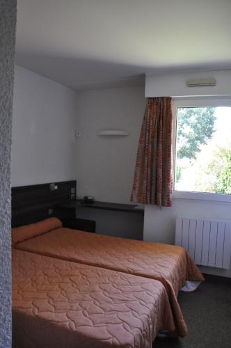 a bedroom with a bed and a window at Henri 4 in Rostrenen