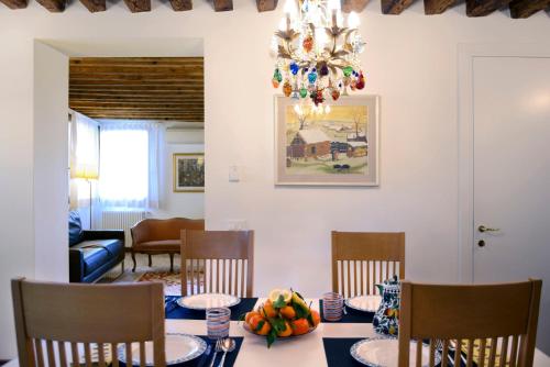 uma sala de jantar com uma mesa com cadeiras e um lustre em Casa Fondamente Nuove em Veneza